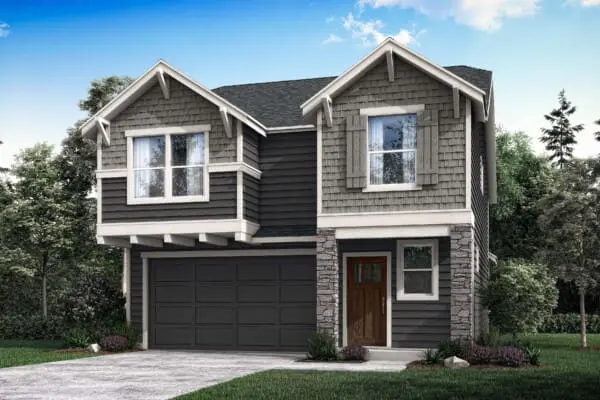 Two-story modern suburban house with dark gray siding, stone accents, a double garage, and a wooden front door. The yard is landscaped with shrubs and trees, and the sky is clear with a few clouds.