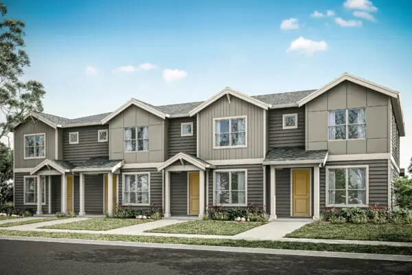 A row of modern two-story townhouses with gray siding, large windows, and yellow front doors, surrounded by small green lawns and shrubs, under a blue sky.